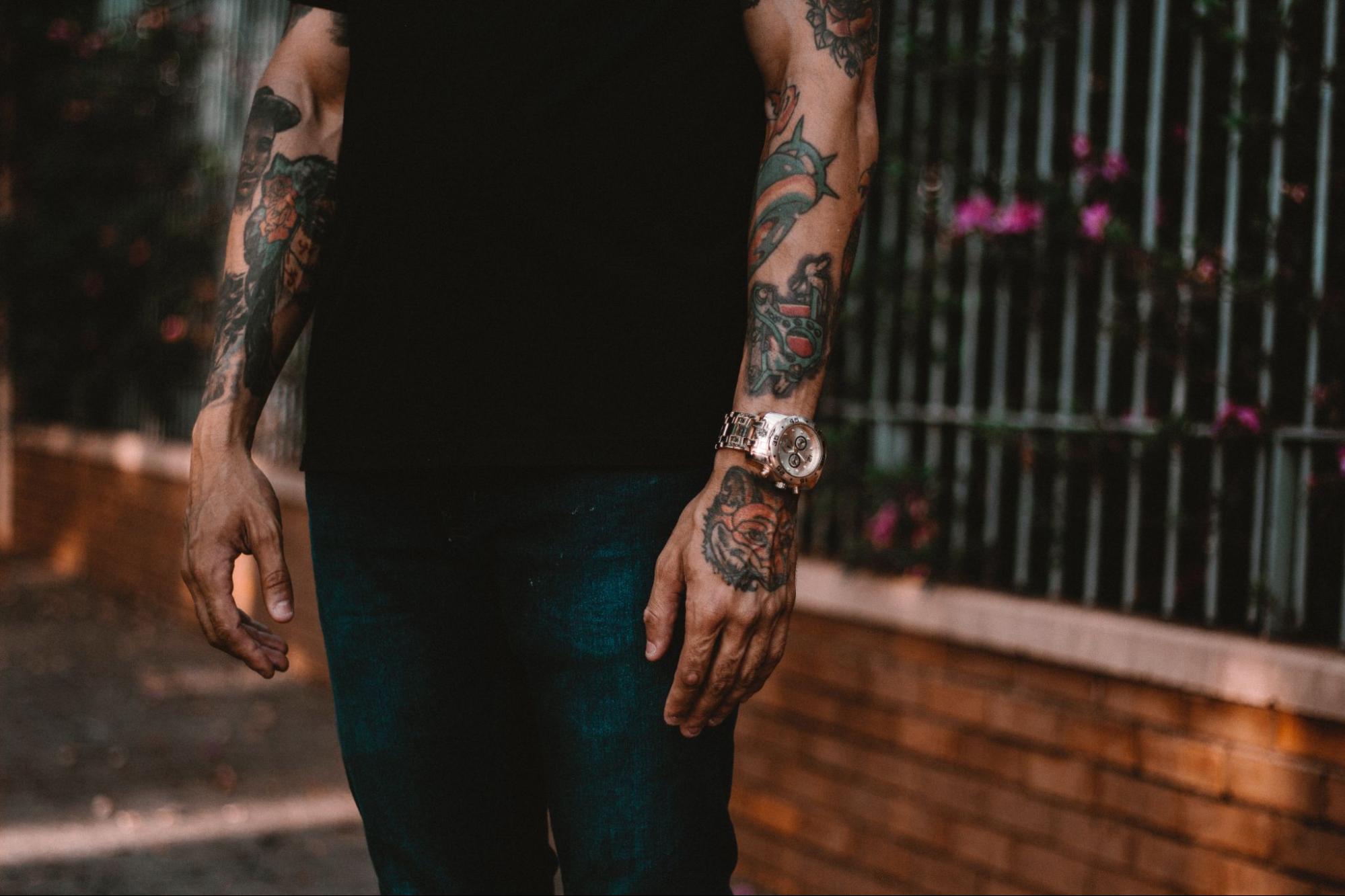 A man with tattoed forearms and a watch