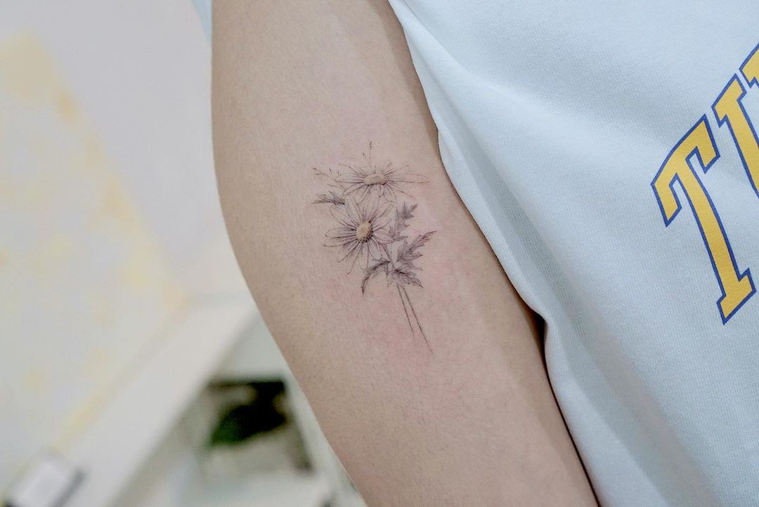 Daisy flower tattoo located on the wrist.