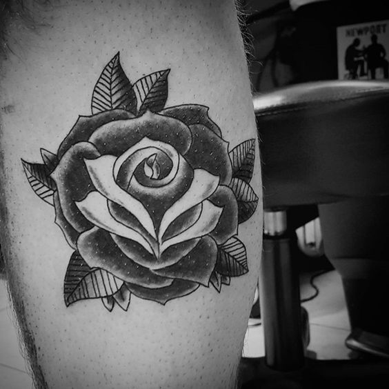 Black rose tattoo on a man's lag