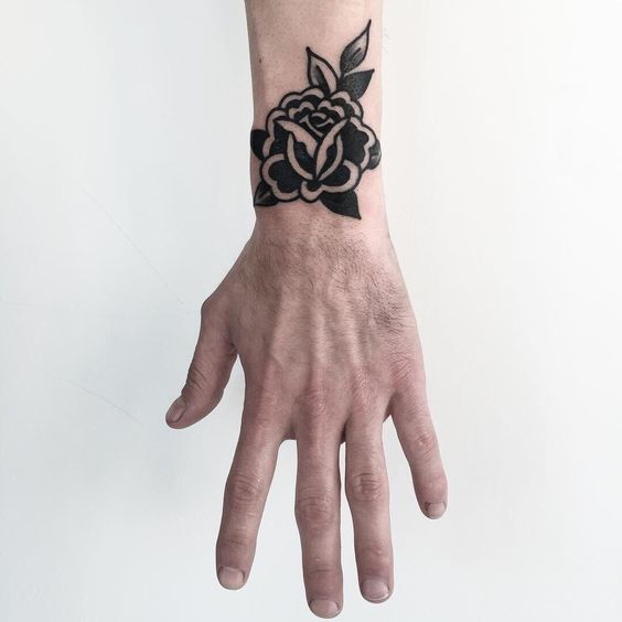 Traditional black rose tattoo on the arm