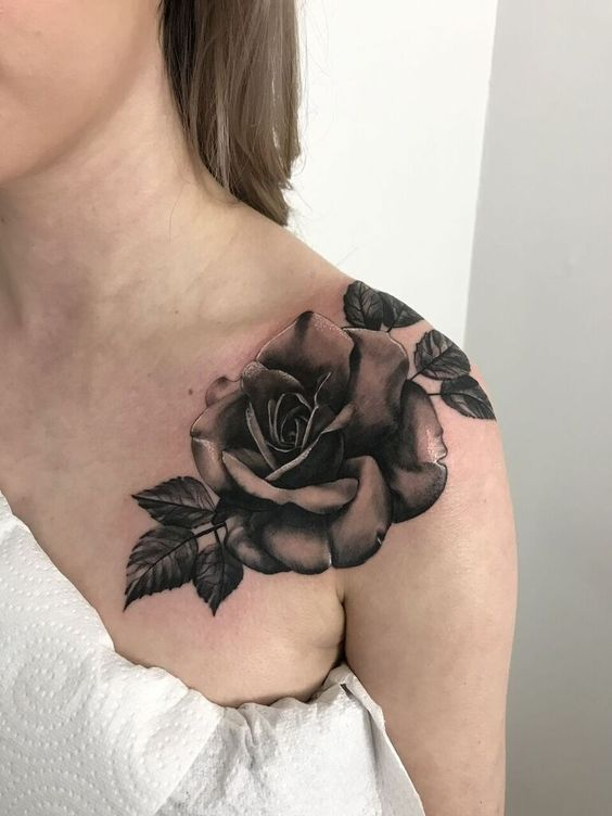 Black rose tattoo on a wonam's shoulder