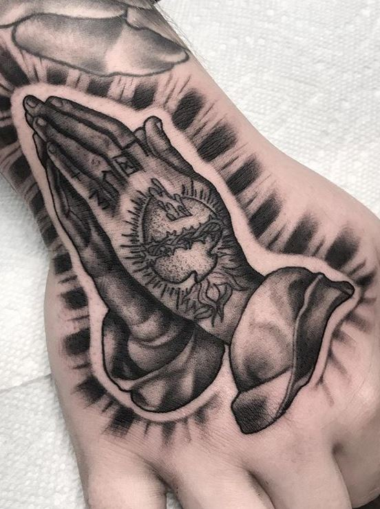 Black and grey style praying hands on the chest