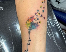 Watercolor style fairy and dandelion seed tattoo on the